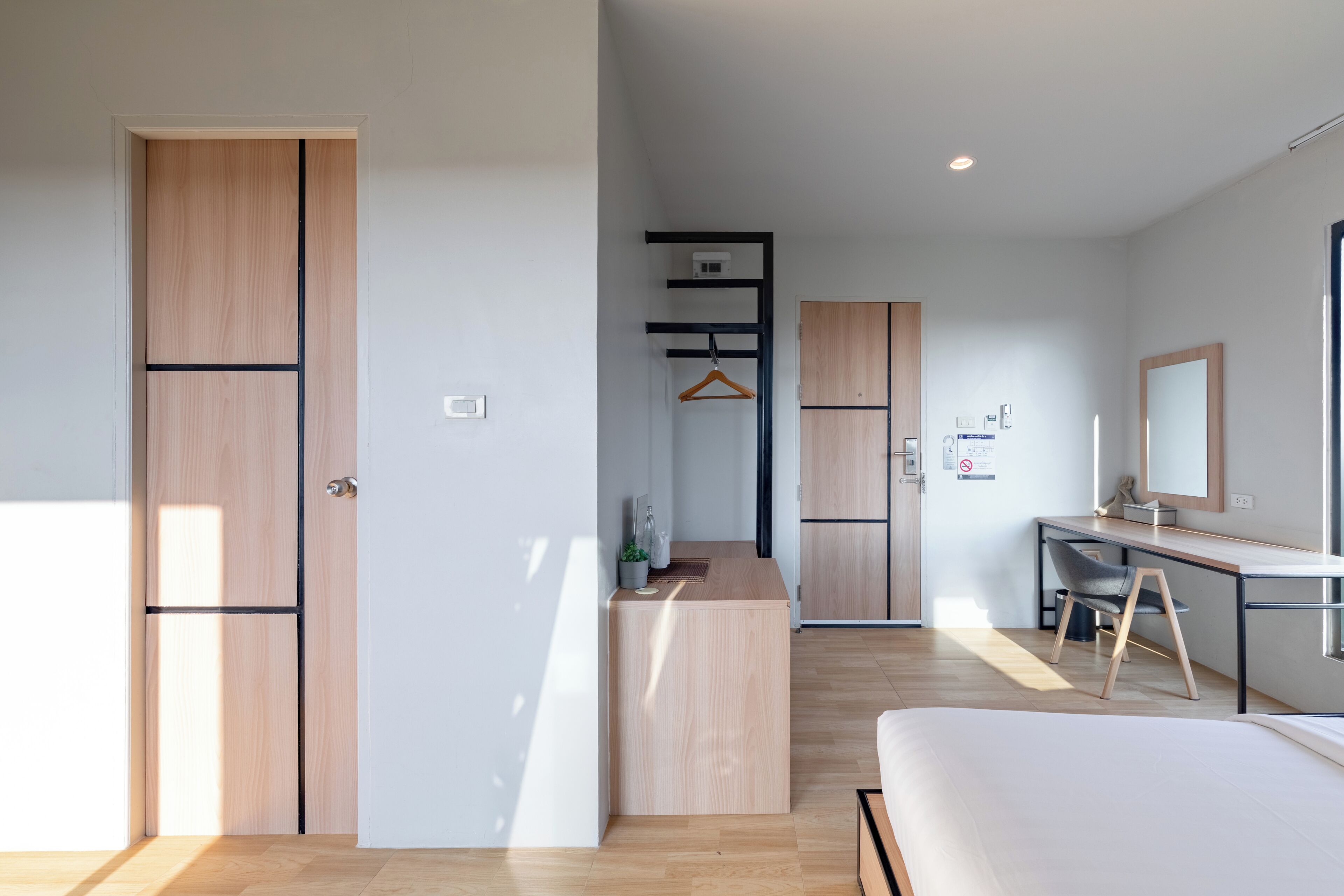 Una habitación de hotel moderna con cama, escritorio y armario.