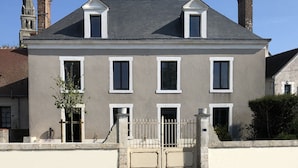 A two-story house with a grey facade, white trim, and a gated entrance. - CHEZ LULU, town house overlooking the Beuvron (Candé-sur-Beuvron)