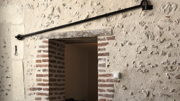 A hot tub with a control panel, a brick wall, and a door leading to a room. - CHEZ LULU, town house overlooking the Beuvron (Candé-sur-Beuvron)