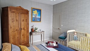 A baby room with a crib, a wooden wardrobe, a small table with a violin, and a painting on the wall. - Cottage for 7 people 15 minutes from Puy du Fou (Pouzauges)