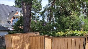 Una valla de madera con un sendero de ladrillo que lleva a una casa.