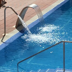 A swimming pool with a water feature.