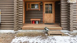 A log cabin with a wooden front door, a bench outside, and a sign reading "JANKA-LUPPO". - Jänkäluppo 1 by Interhome (Äkäslompolo)