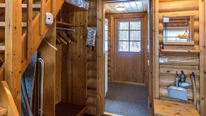 A wooden cabin interior with a wooden staircase, a door leading to a room, and a small shelf with items. - Jänkäluppo 1 by Interhome (Äkäslompolo)