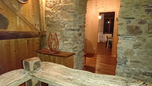 Un intérieur rustique avec des murs en pierre, des meubles en bois et une cheminée en pierre.