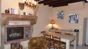 Un comedor acogedor con chimenea de ladrillo, mesa de madera y sillas.