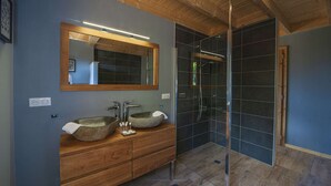 A bathroom with a wooden vanity, two sinks, a large mirror, and a glass-enclosed shower area. - Inuï Grand Chalet - 5-star luxury spa (Muhlbach-sur-Munster)