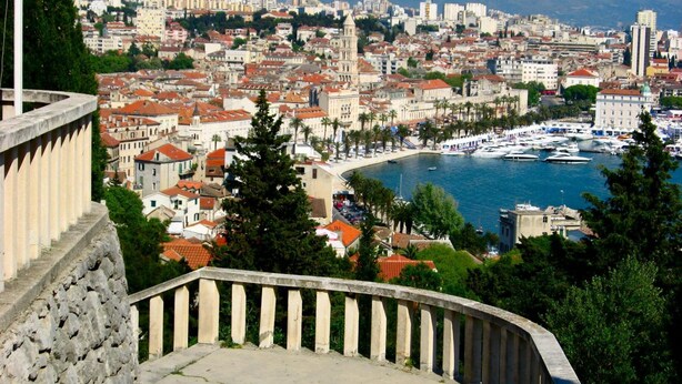 A coastal cityscape with a prominent church, a marina with boats, and a stone balustrade. - 7heaven Luxury Rooms Palace (Split)