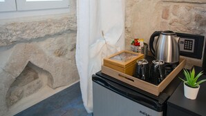 A compact kitchenette with a coffee maker, a small fridge, and a wooden box containing bottles. - 7heaven Luxury Rooms Palace (Split)