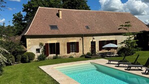 A two-story house with a swimming pool, a patio with lounge chairs, and a well-maintained lawn. - Beautiful 1900 Demeure with swimming pool and enclosed garden, in a charming village (Apremont-sur-Allier)