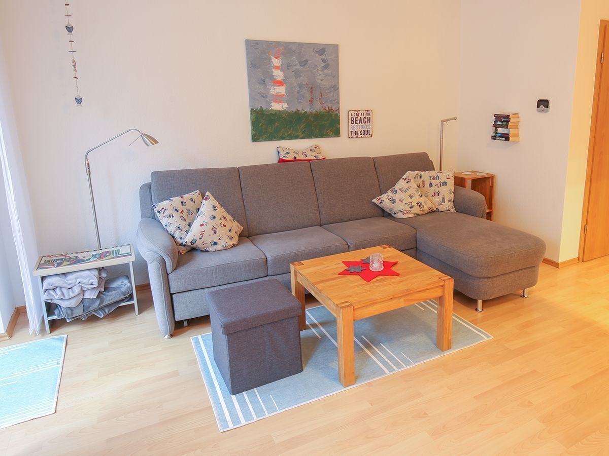 A living room with a grey sofa, a wooden coffee table, and a small side table.
