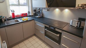 A modern kitchen with a built-in oven, a coffee maker, and a toaster.