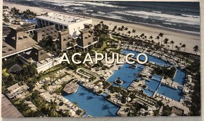 An aerial view of a resort with multiple swimming pools, palm trees, and a beach. - Ocean front Resort  StudioMaster  (2A&2K) with Golf (2x1) in Mayan Palace in AP (Acapulco)