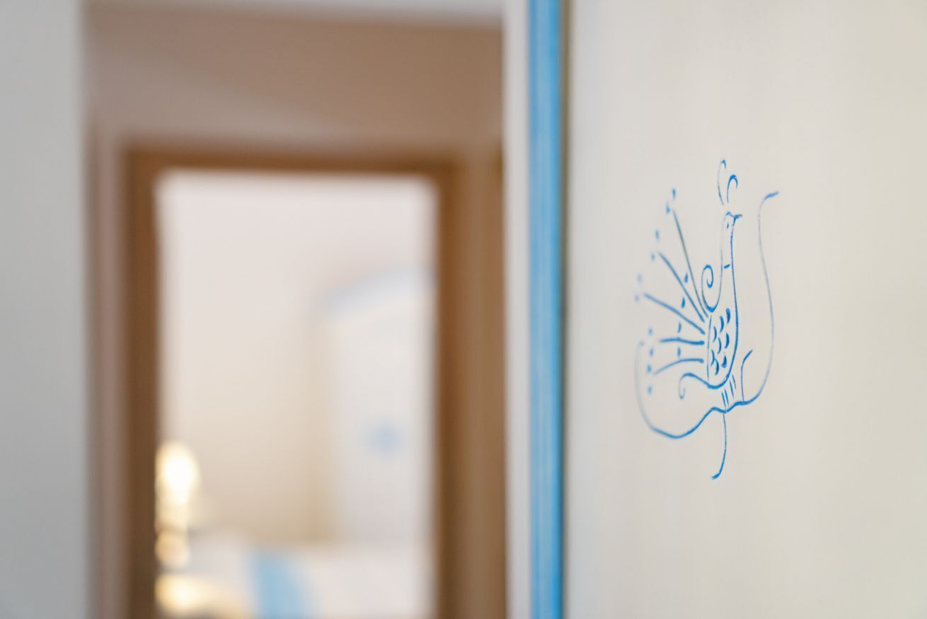 Een muur met een blauwe tekening van een vogel.