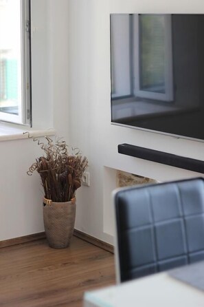 Apartamento superior, vista para a marina | Sala de estar | TV de tela plana 97 cm com canais via satélite, TV