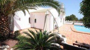 A white building with a pool, surrounded by palm trees and a tiled patio. - Santa Belgica, Altea (Altea)