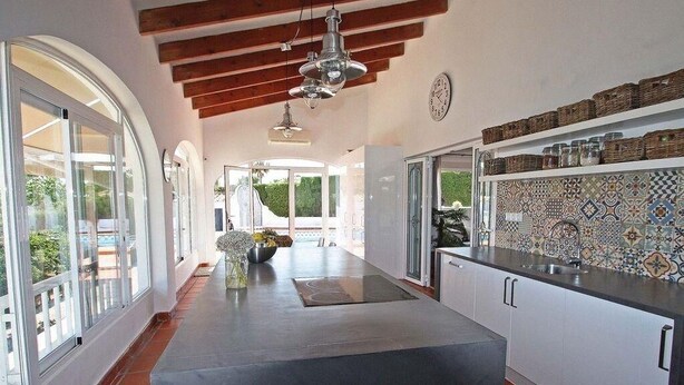 A modern kitchen with a central island, white cabinetry, and a tiled backsplash. - Santa Belgica, Altea (Altea)