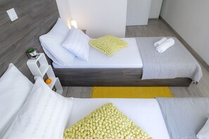 A modern hotel room with a bed, bedside tables, and a small plant. - Comfort Apartment with Pool and Terrace (Novalja)