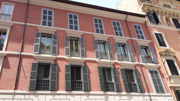 A multi-story building with red brick facade, multiple balconies with metal railings, and a mix of window styles. - Bright apartment in the Center of Rome 70 sqm wifi near Piazza di spagna (Roma)