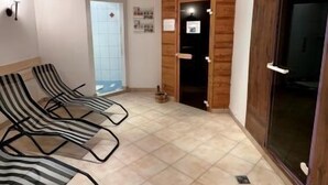Una habitación con cuatro sillones reclinables a rayas, una pared de madera y un piso de baldosas.