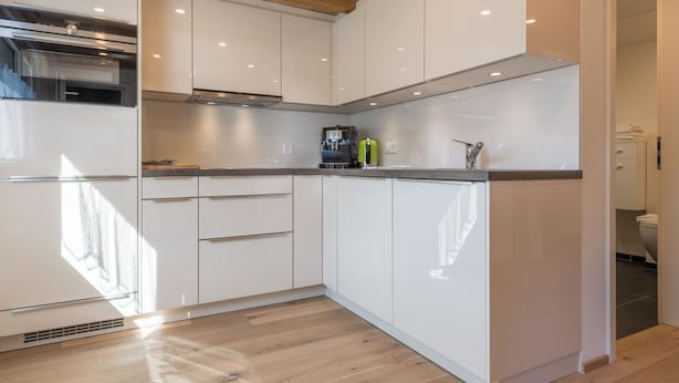 A modern kitchen with white cabinets, a built-in oven, and a coffee machine. - Haus Bergsonne by Interhome (Saas-Almagell)
