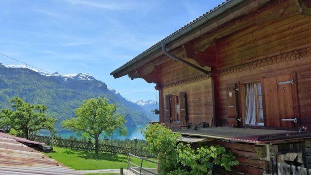 A wooden cabin with a balcony overlooking a lake and mountains. - Boden 19 by Interhome (Brienz)