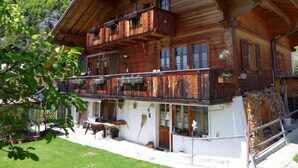 A wooden chalet with a balcony, a covered porch, and a view of the surrounding forest. - Boden 19 by Interhome (Brienz)