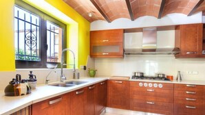 A kitchen with wooden cabinets, a gas stove, and a sink. - La Tilia II by Interhome (Calonge)