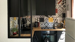A compact kitchen with dark cabinets, a coffee maker, and a microwave.