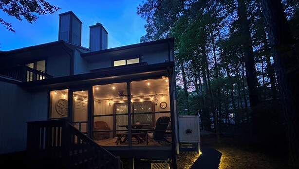 Ein modernes Haus mit Glasfront, einem Essbereich und einer Treppe zum Eingang.