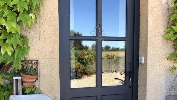 A dark wooden door with a glass panel, a potted plant, and a sign indicating a rental property.