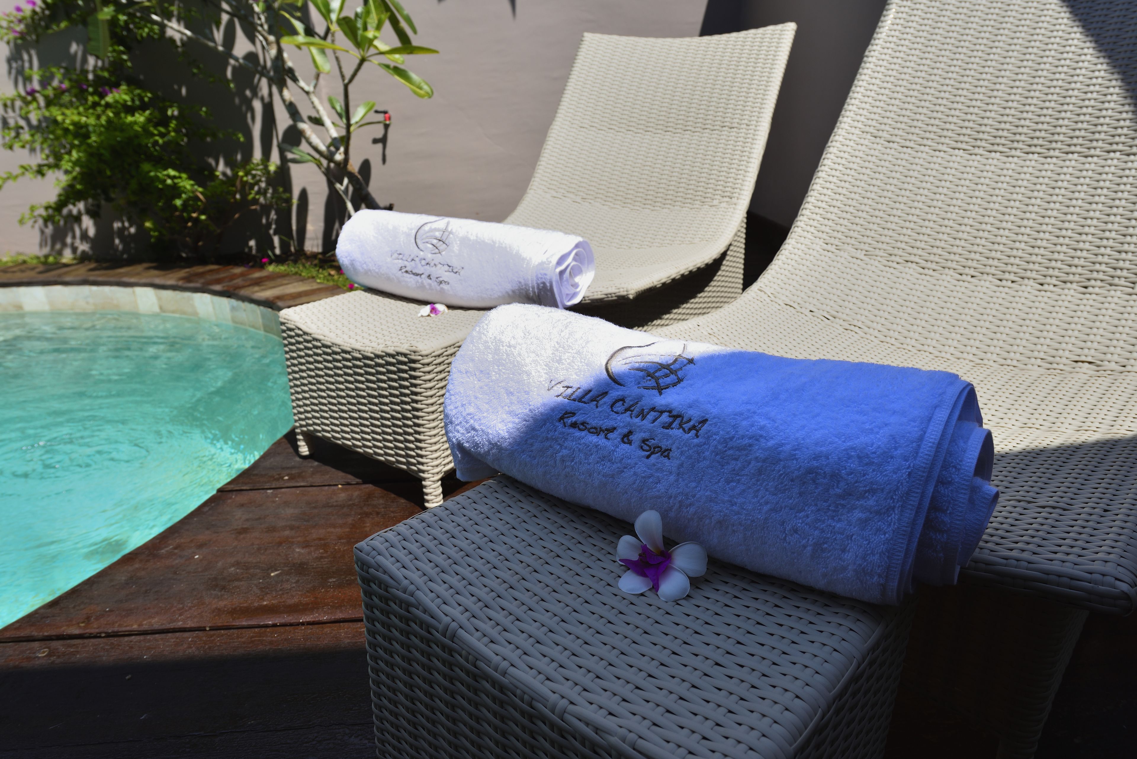 Zona de piscina con sillas de descanso y toallas.