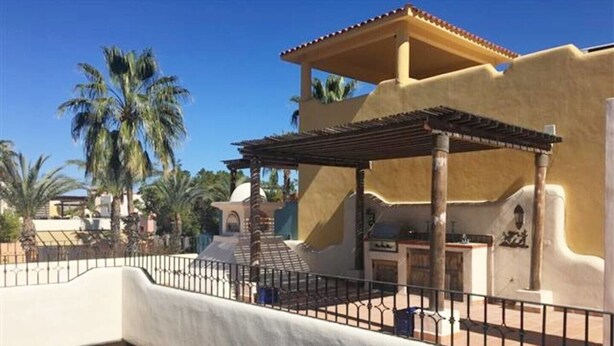 A building with a covered patio, a pergola, and a pool area.