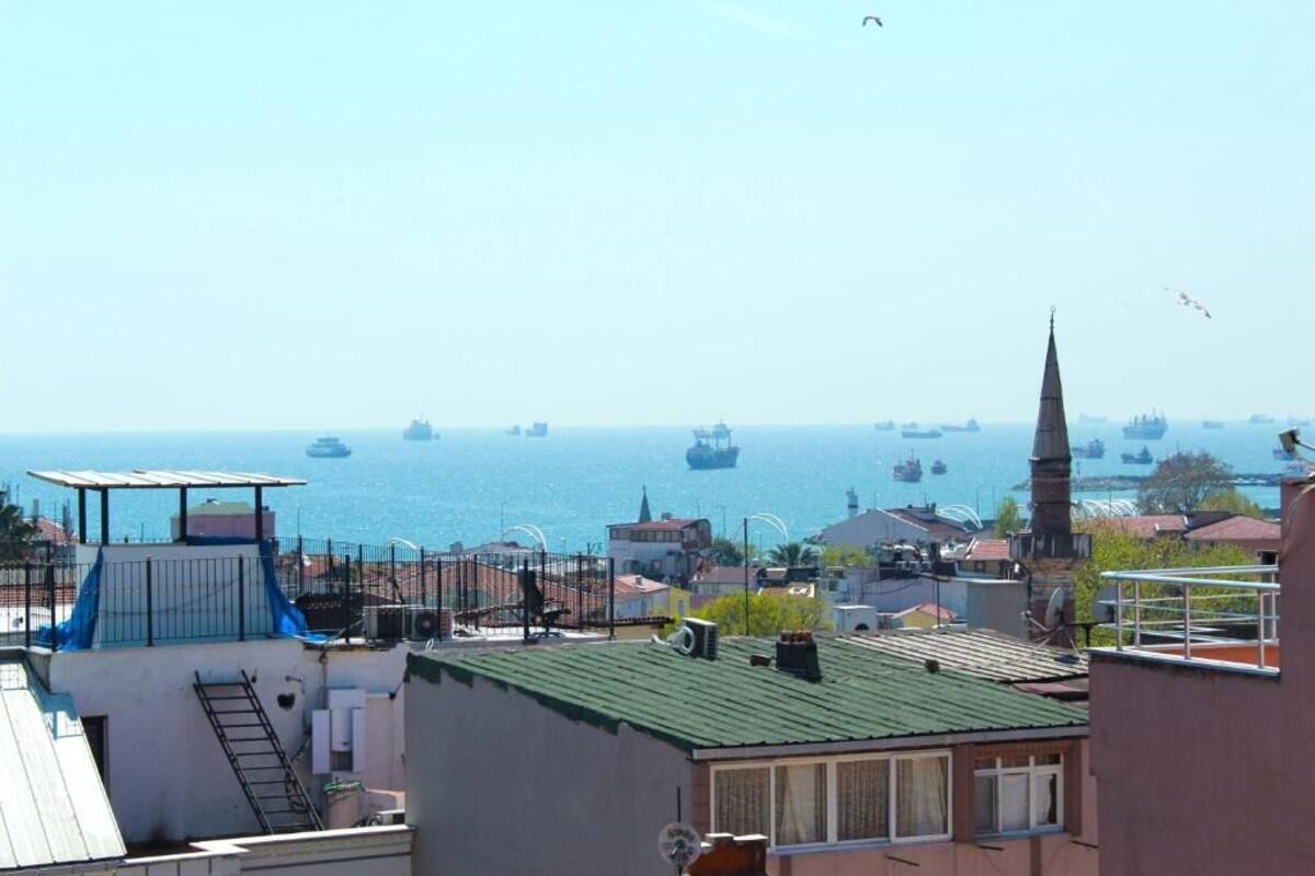 A coastal cityscape with a view of the sea and several ships.