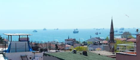 A coastal cityscape with a view of the sea and several ships.