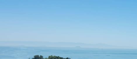 A coastal cityscape with buildings and a clear view of the sea.