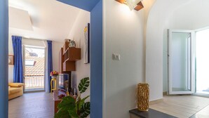 Una sala de estar moderna con un sofá, una mesa de centro, un televisor y una planta grande.