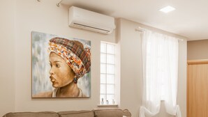 A modern living room with a brown sofa, a wooden coffee table, and a painting on the wall. - Monastiraki Urban Apartments (Athens)