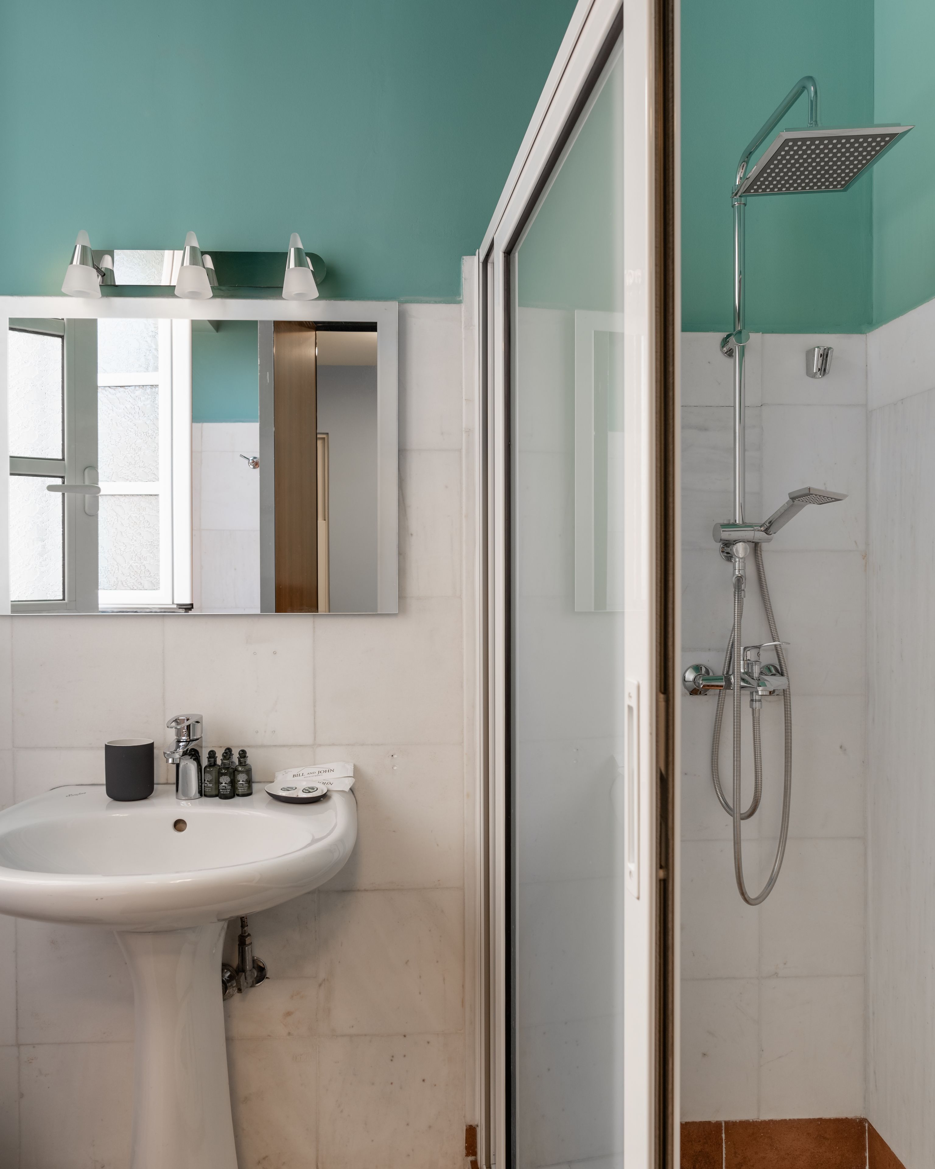 Une salle de bain avec un lavabo, un miroir et une douche.