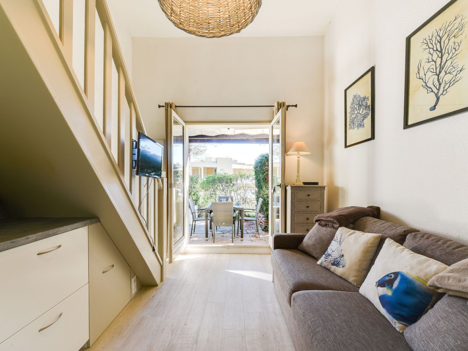 A hallway with a sofa, a TV, and a dining area with a table and chairs.