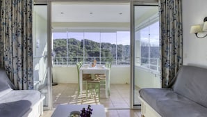 Ein geräumiges Wohnzimmer mit Balkon, Essbereich und einer Couch.
