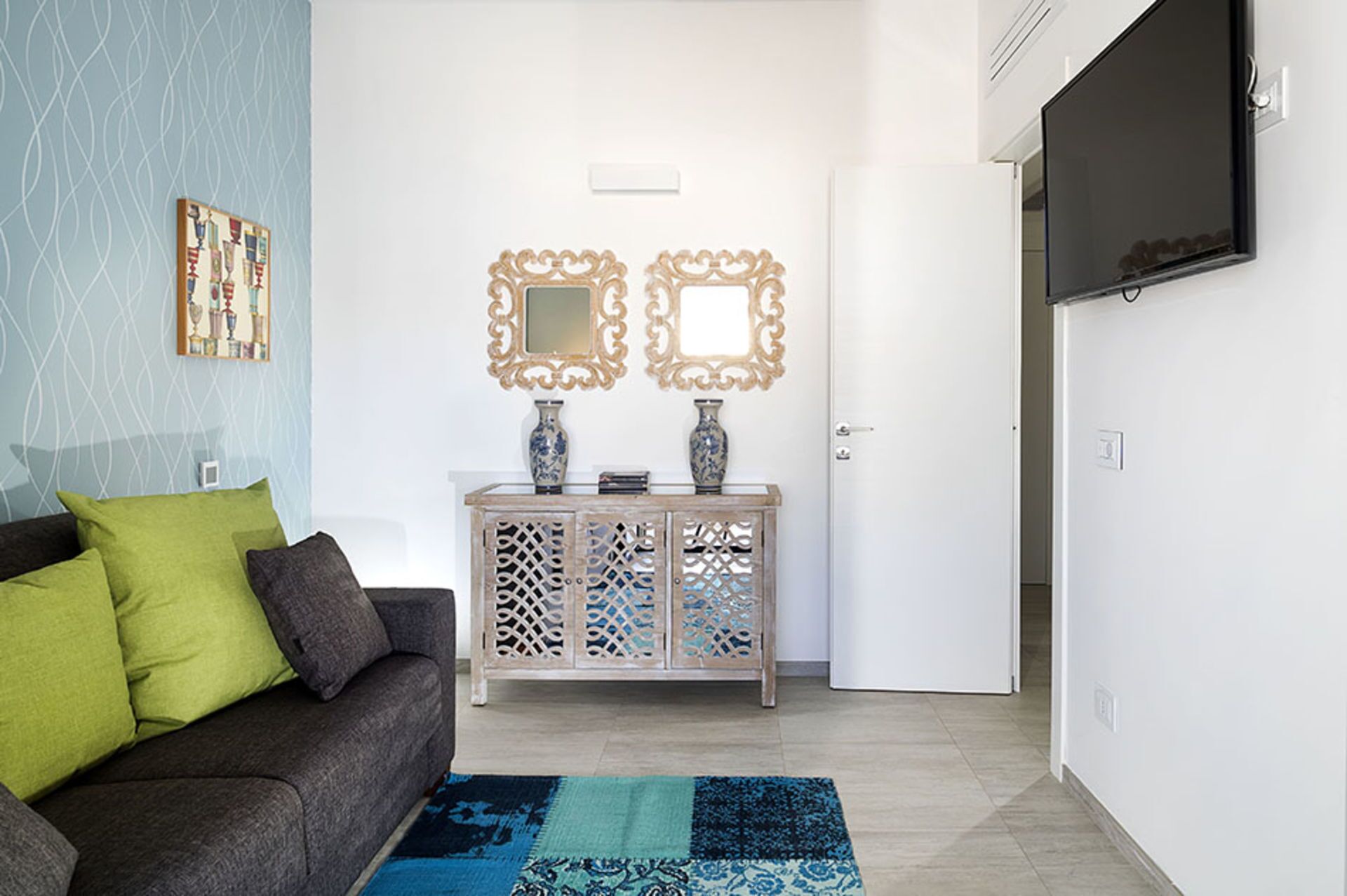 Ein Wohnzimmer mit Sofa, Couchtisch, Fernseher und Dekorationselementen.