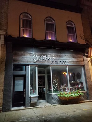 A storefront with the name "Stiletto & Sawdust" illuminated at night. - Debonaire Suite: Modern - Calm - Downtown (Stratford)