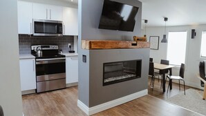 Een moderne keuken met een ingebouwde magnetron, oven en een open haard.