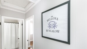 Um letreiro emoldurado na parede com o texto 'The Bellona Bungalow' e o logotipo de um caranguejo.