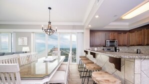 Una cocina amplia con una isla grande, taburetes de bar y vistas a la ciudad.