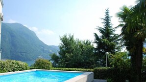 Una piscina con vista a una montaña y un lago.