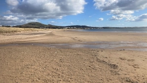 A wide sandy beach with gentle waves, a clear sky, and distant hills. - Kirkside Cottage pet friendly, sleeps 4 near St Andrews (Upper Largo)