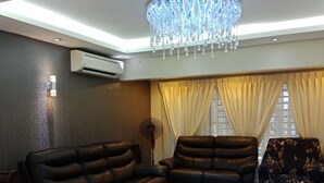 A modern living room with a black leather sofa, a matching recliner, a glass coffee table, and a chandelier. - The house is very strategic area. Nice and beautiful (Petaling Jaya)