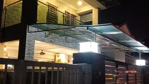 A two-story modern house with a glass balcony, a gated entrance, and a visible upper floor with a balcony. - The house is very strategic area. Nice and beautiful (Petaling Jaya)